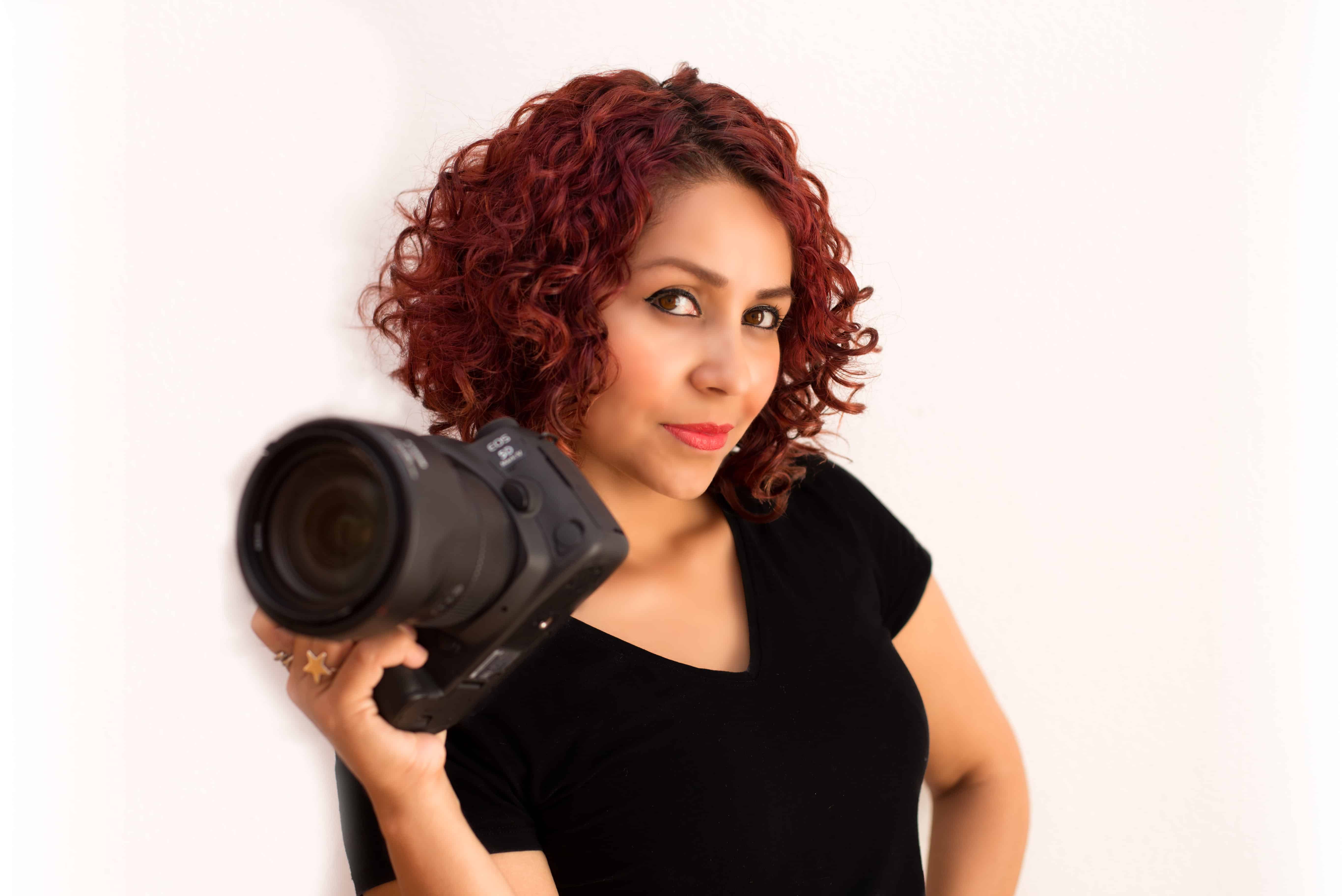 Liza Flores sosteniendo su cámara fotográfica