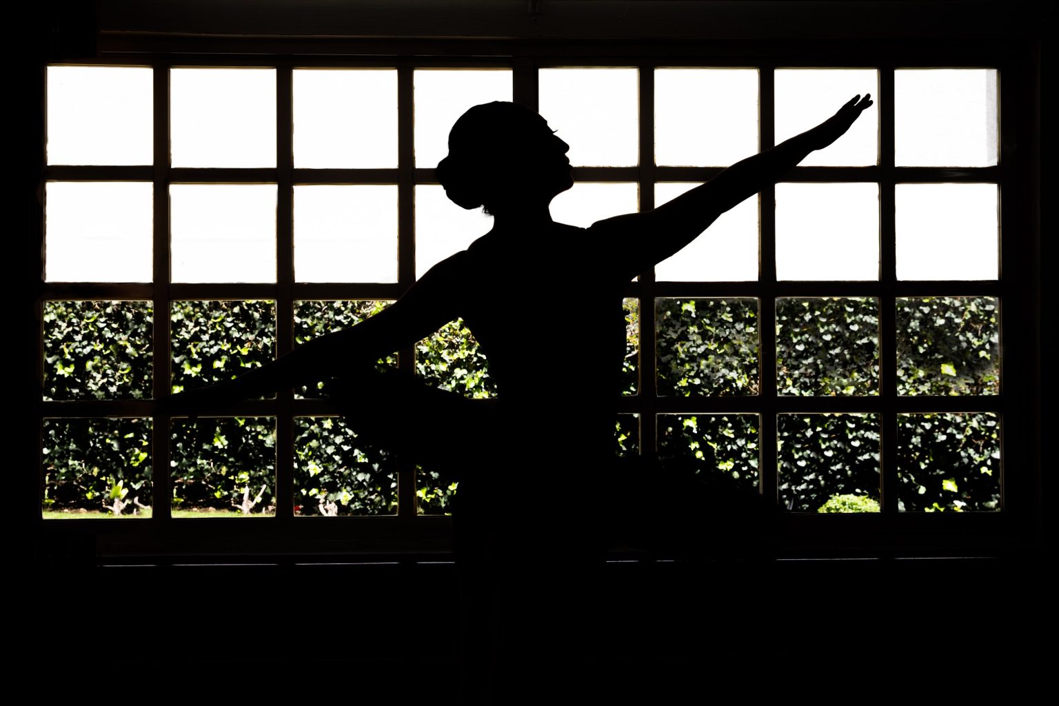 Silueta de una bailarina frente a una gran ventana