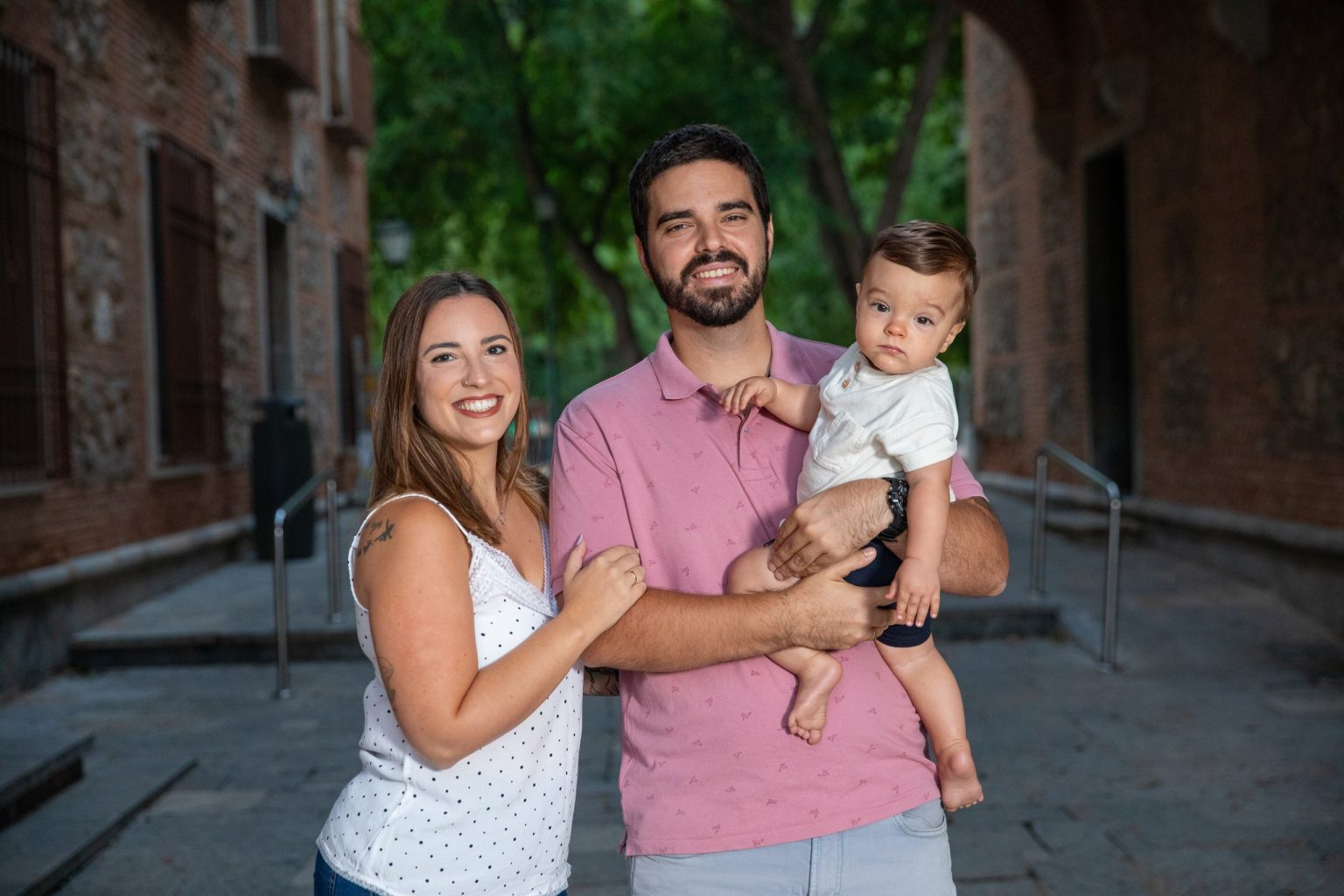 Pareja sonriendo con su bebé durante una sesión familiar