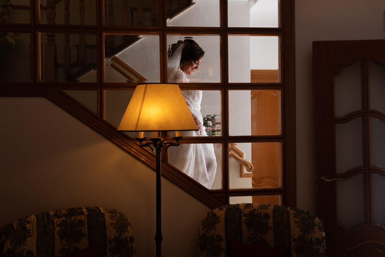 Novia descendiendo una escalera entre luces y sombras