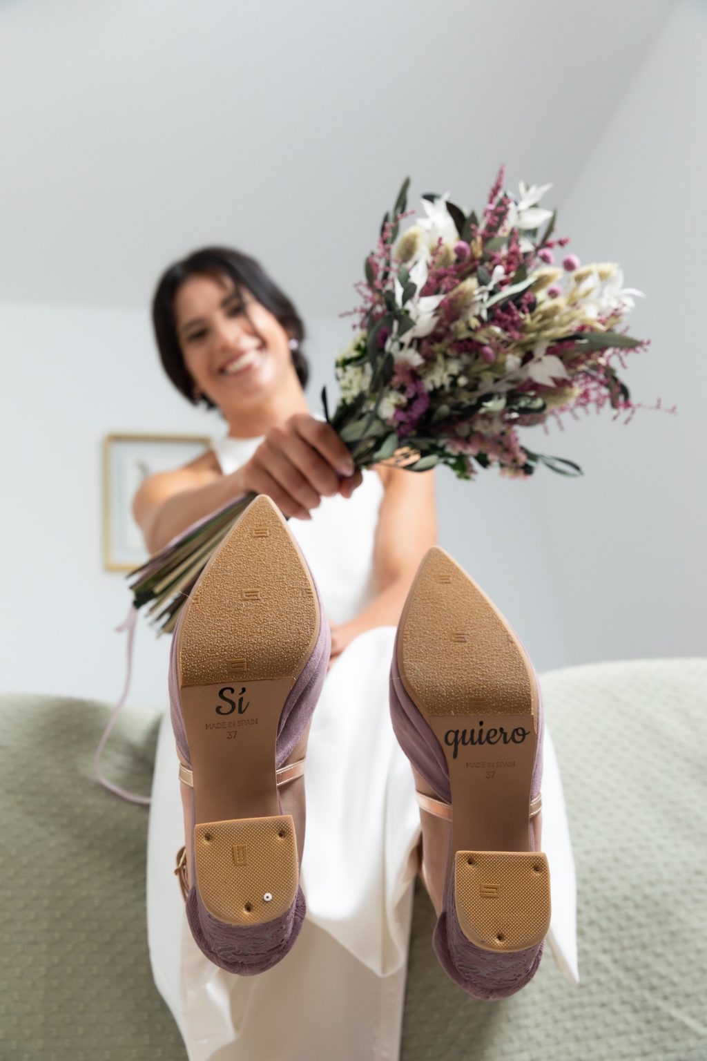 Novia con sus zapatos y el ramo durante los preparativos