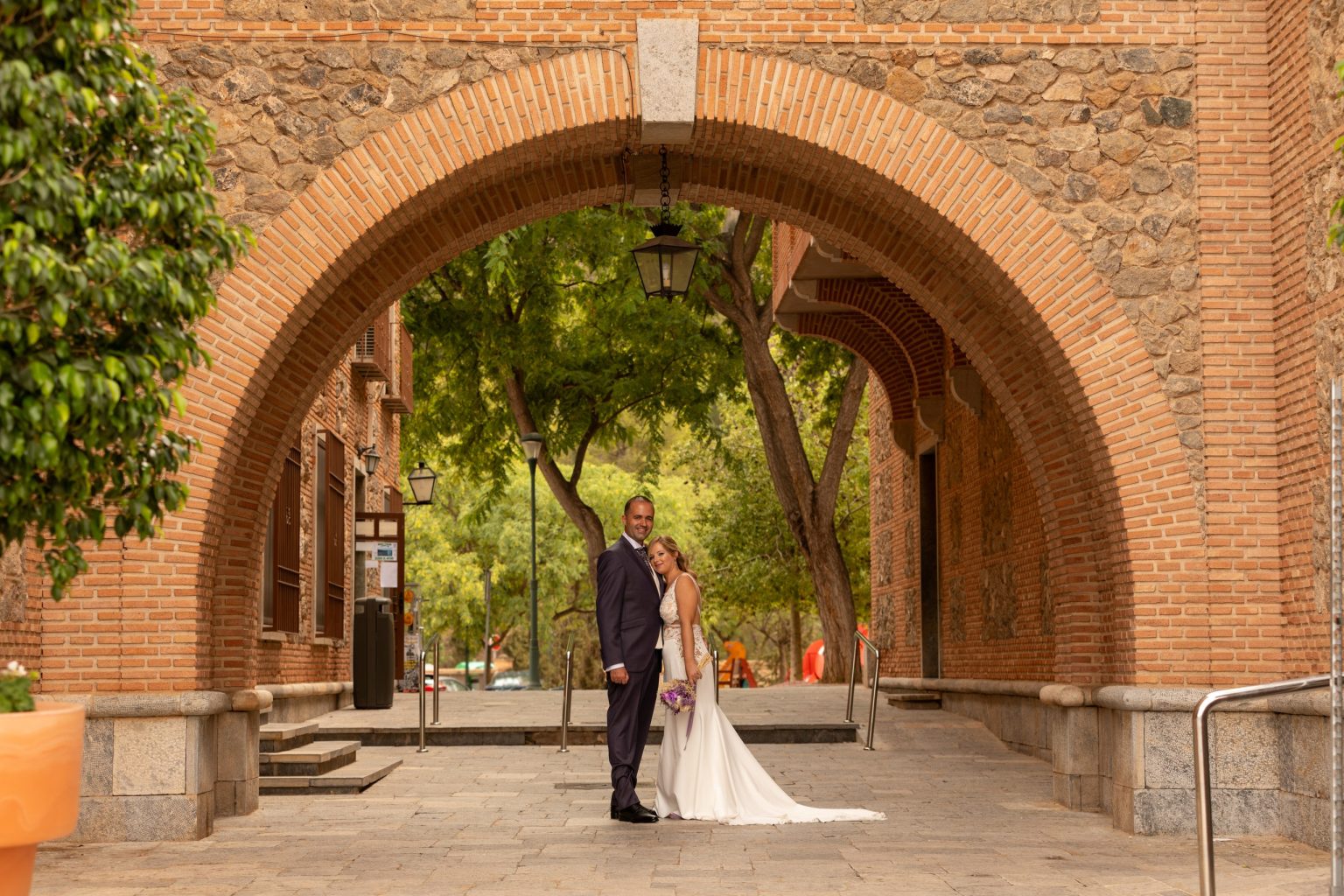 Novios bajo un arco en un jardín