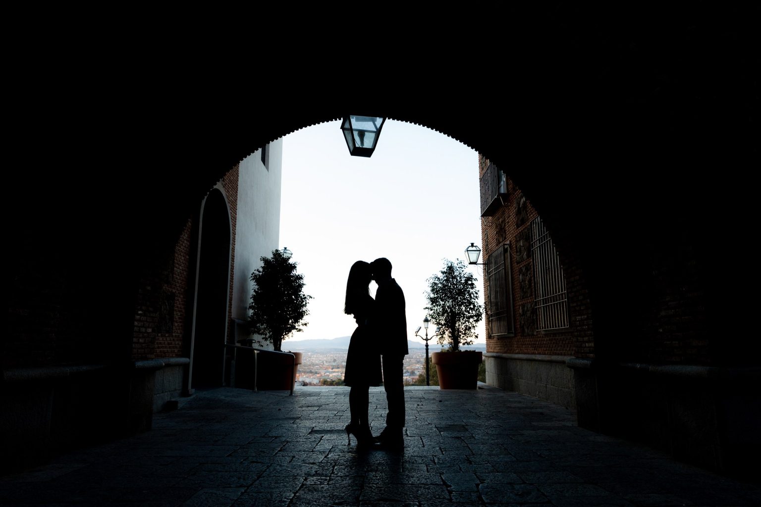 Silueta de una pareja enmarcada por un arco con vistas al mar