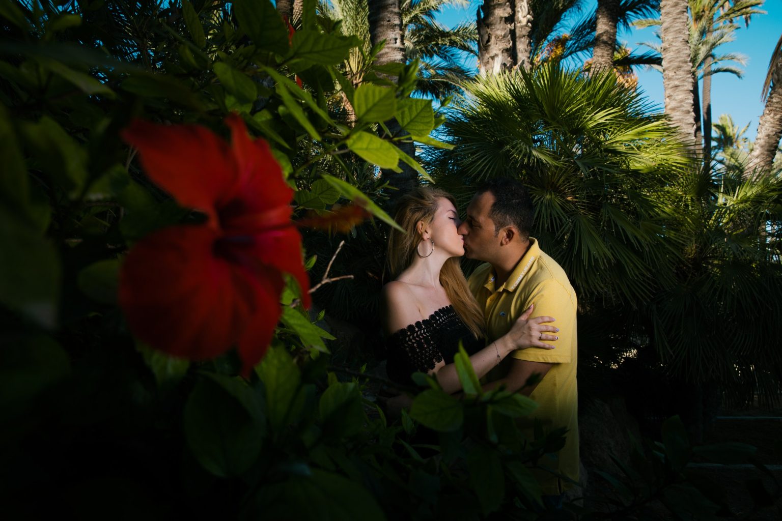 Pareja besándose con una flor durante su sesión preboda