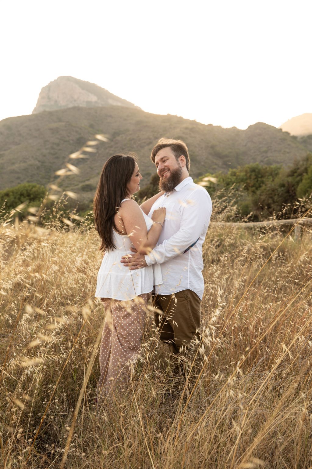 Pareja abrazada durante una preboda entre campo y montaña
