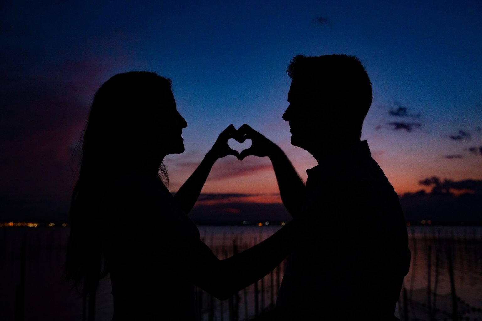 Silueta de una pareja formando un corazón con las manos