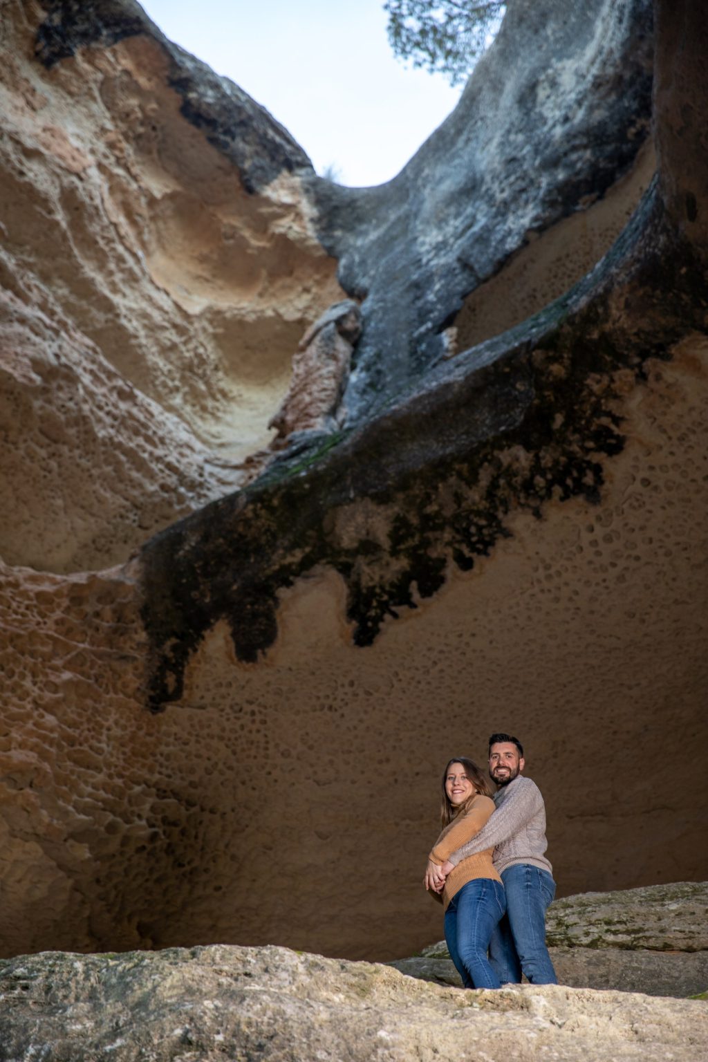 Pareja en una cueva abierta a un paisaje costero