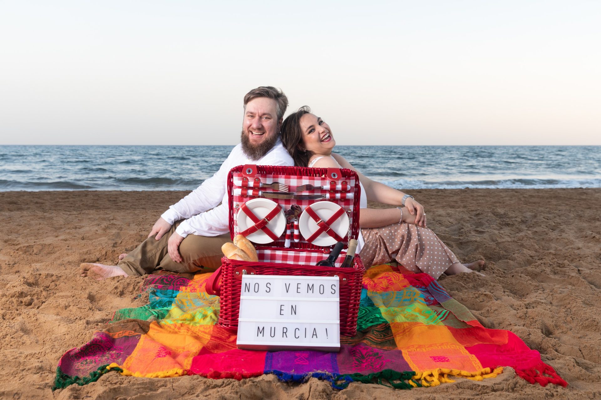 Pareja sentada en la playa durante su sesión preboda en Murcia