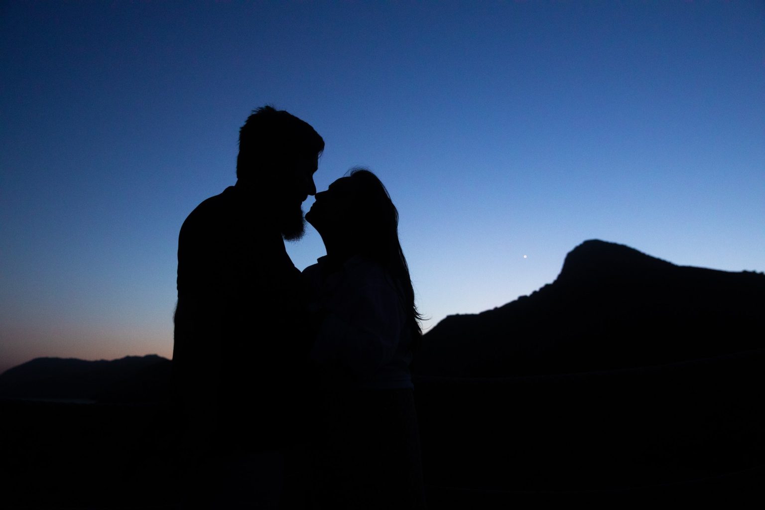Silueta de una pareja ante un paisaje de montaña